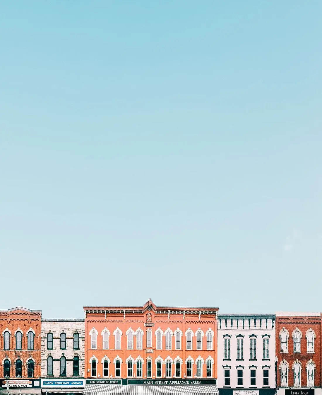 Row of historic brick retail storefronts on an American main street